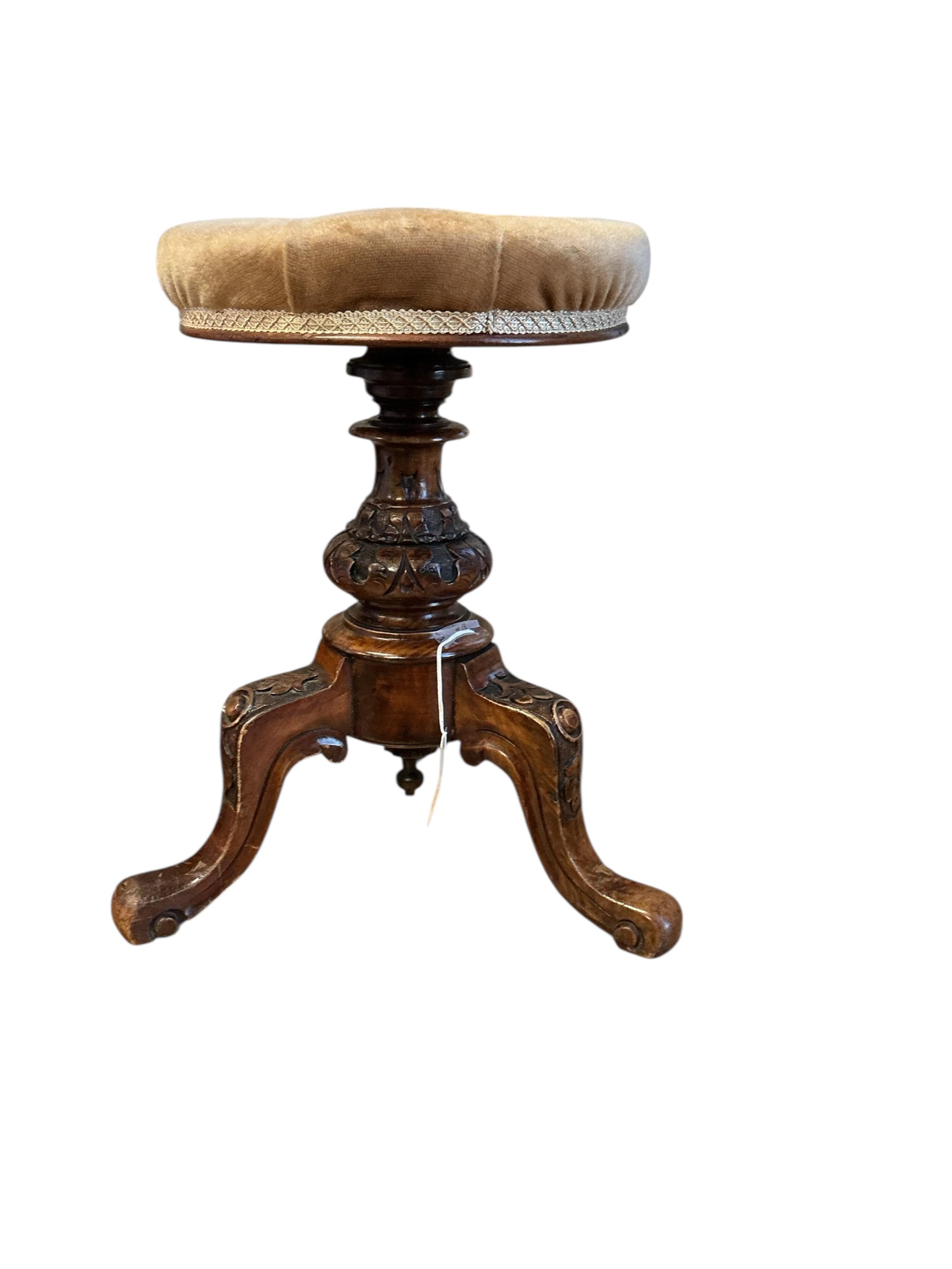 A Victorian walnut revolving piano stool